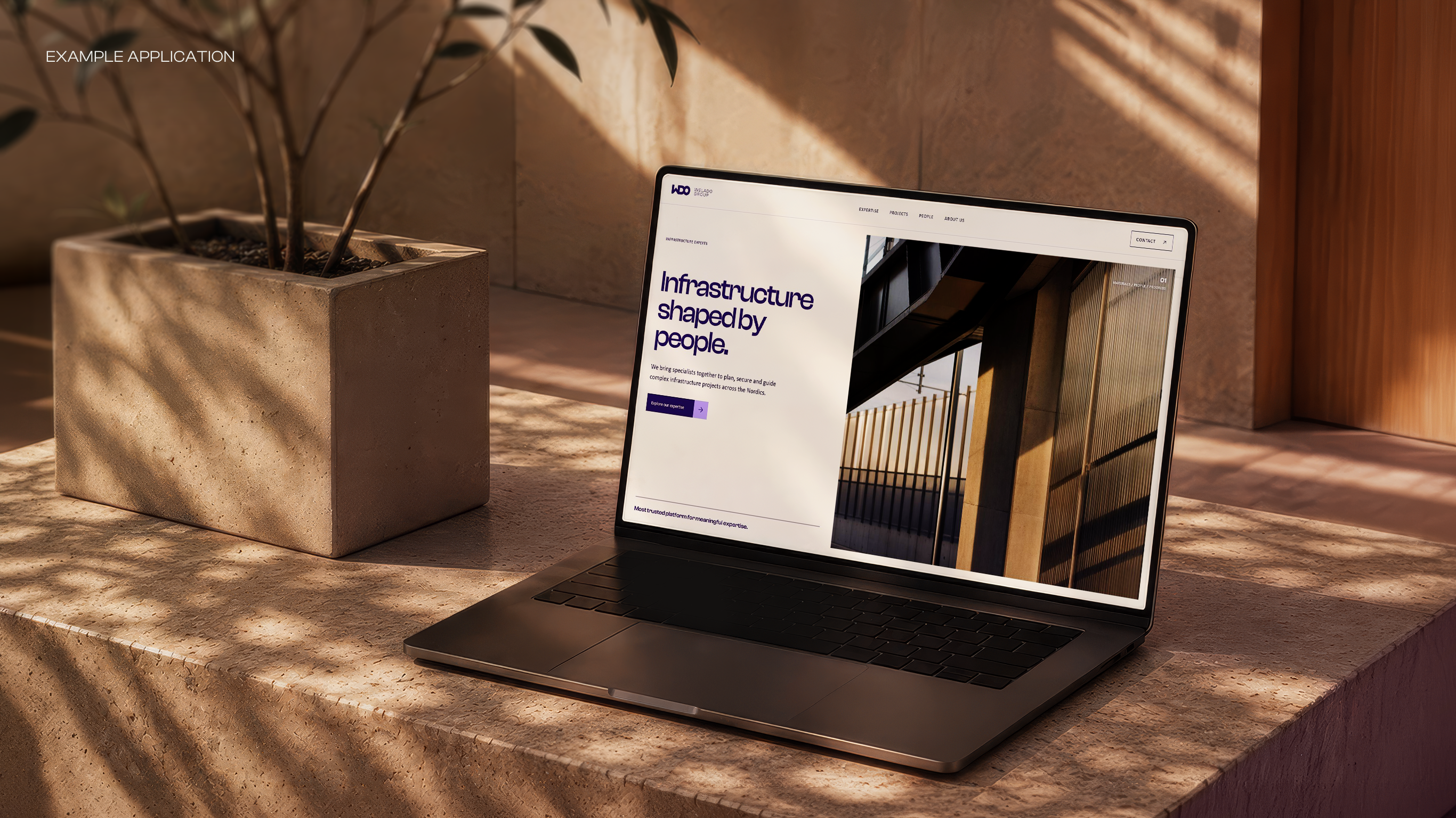 Welado Group website displayed on a laptop in a warm architectural setting